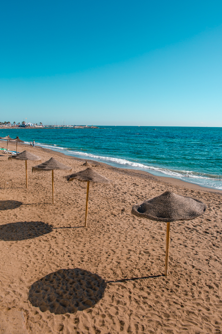 empty beach with sun umbrellas in Marbella, Southern Spain