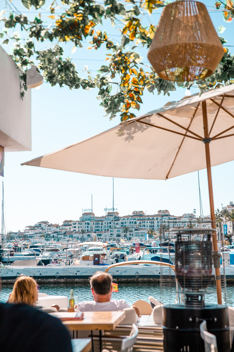 People at a cafe watching over the marina of Puerto Banus, marbella.