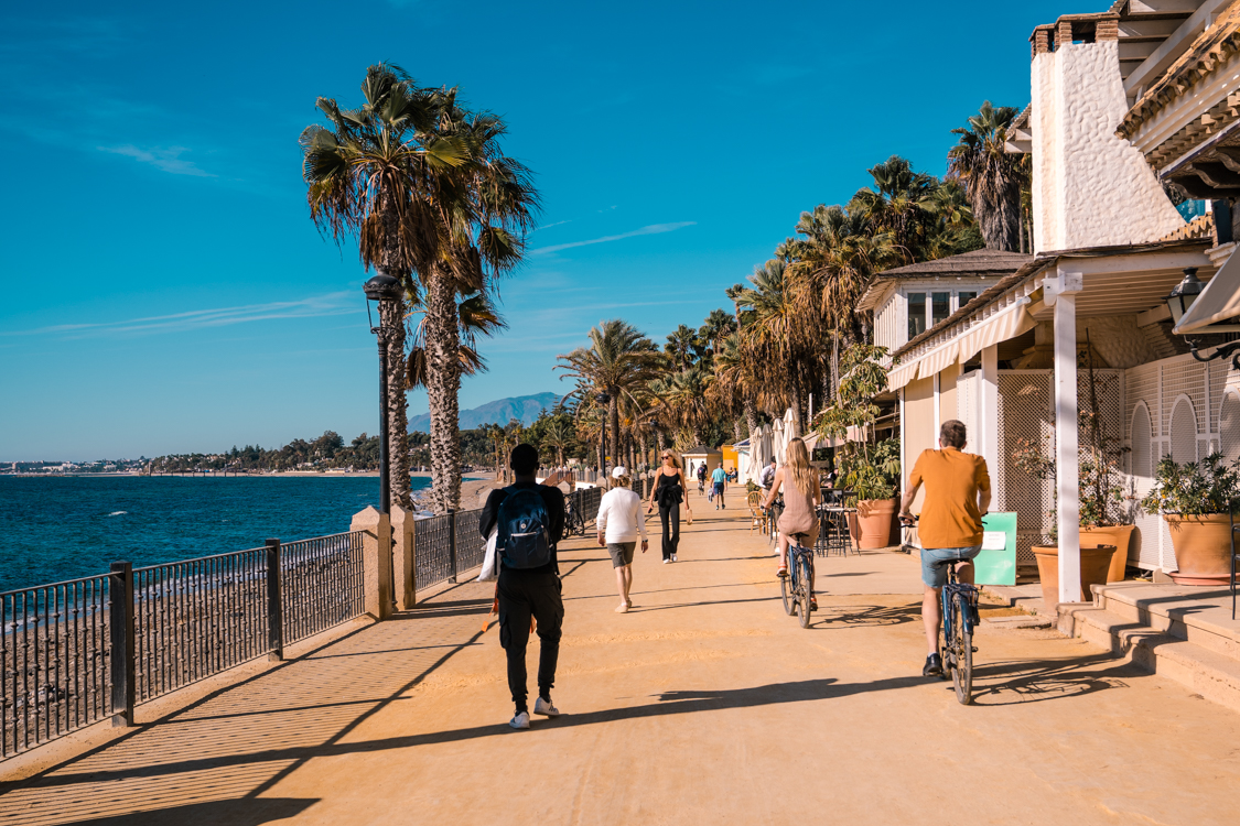 People walking on the coastal promenade in Marbella.