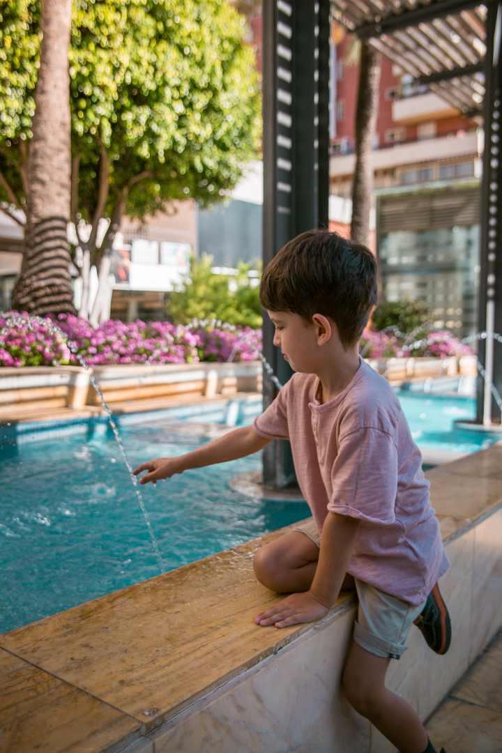 a child enjoying the water features in Avenida del Mar, Marbella