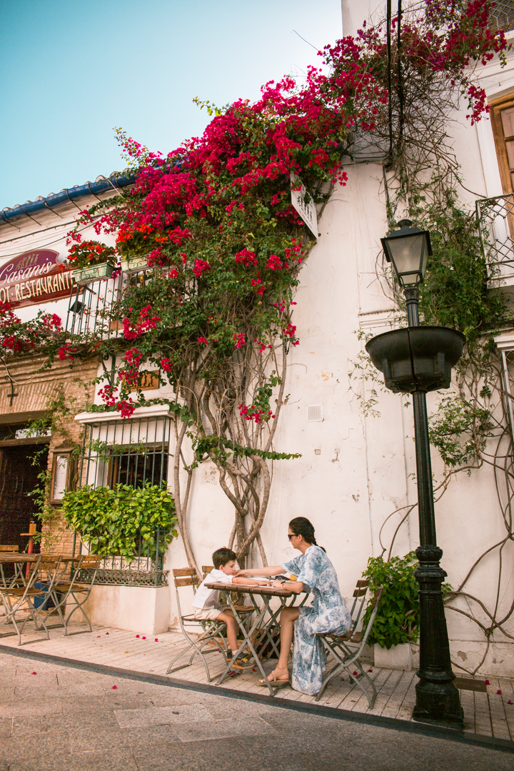 Woman and child sitting in front of a restaurant in Marbella old town, Southern Spain